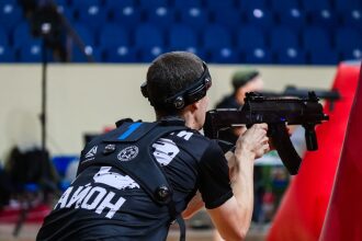 Игрок LASERWAR с автоматом в прицеле у красного препятствия.